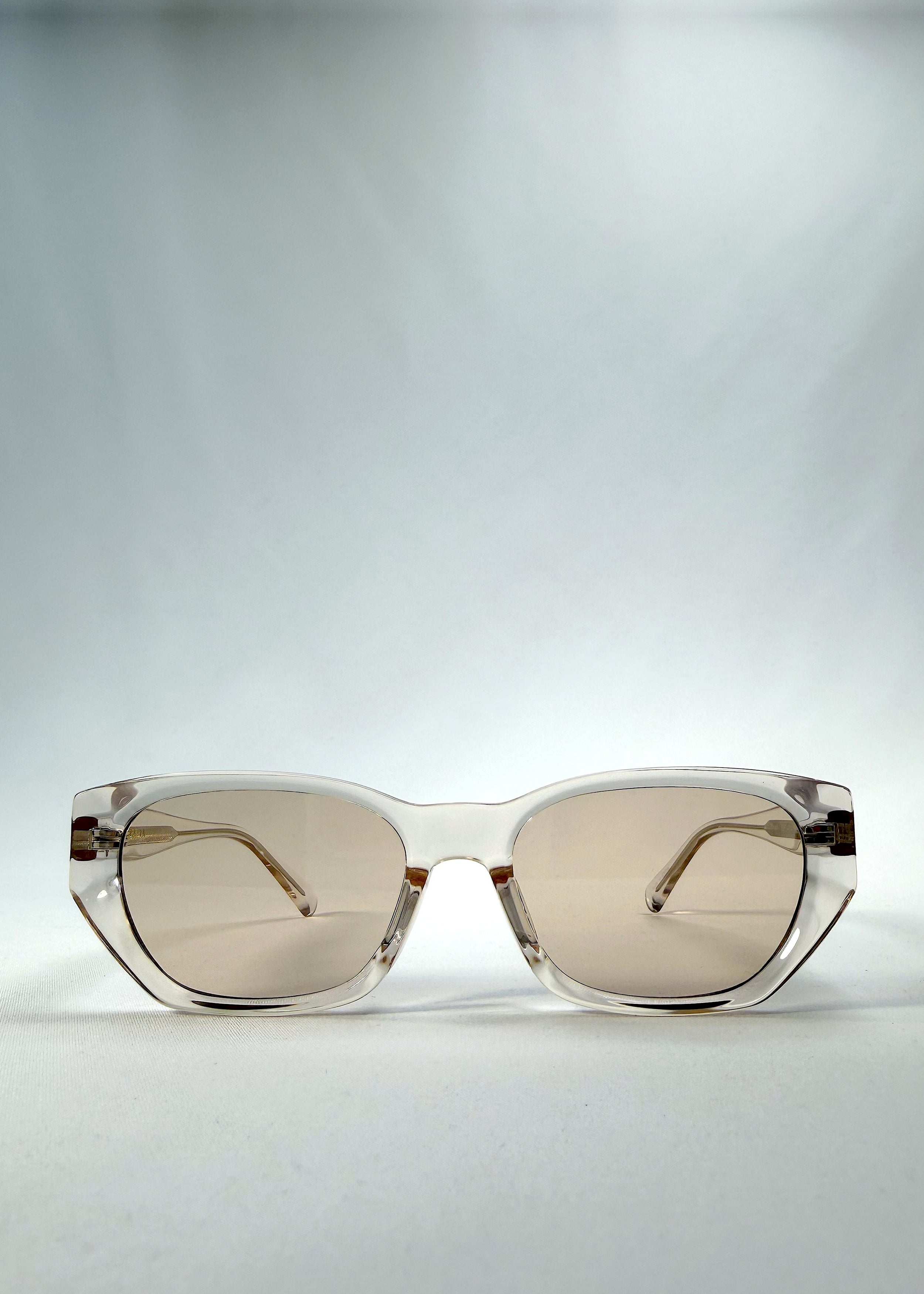 Front view of Mirach sunglasses in Transparent White, featuring crystal-clear acetate frame and tea-tinted lenses, showing the full front silhouette.