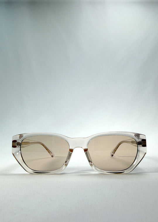 Front view of Mirach sunglasses in Transparent White, featuring a crystal-clear acetate frame and tea-tinted lenses, showing the full front silhouette. 