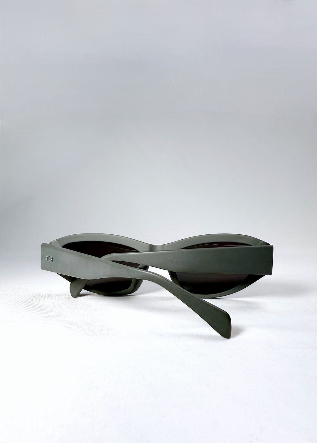 Folded view of Nebula Shade sunglasses in Carbon Ash showing compact silhouette and layered matte texture. 