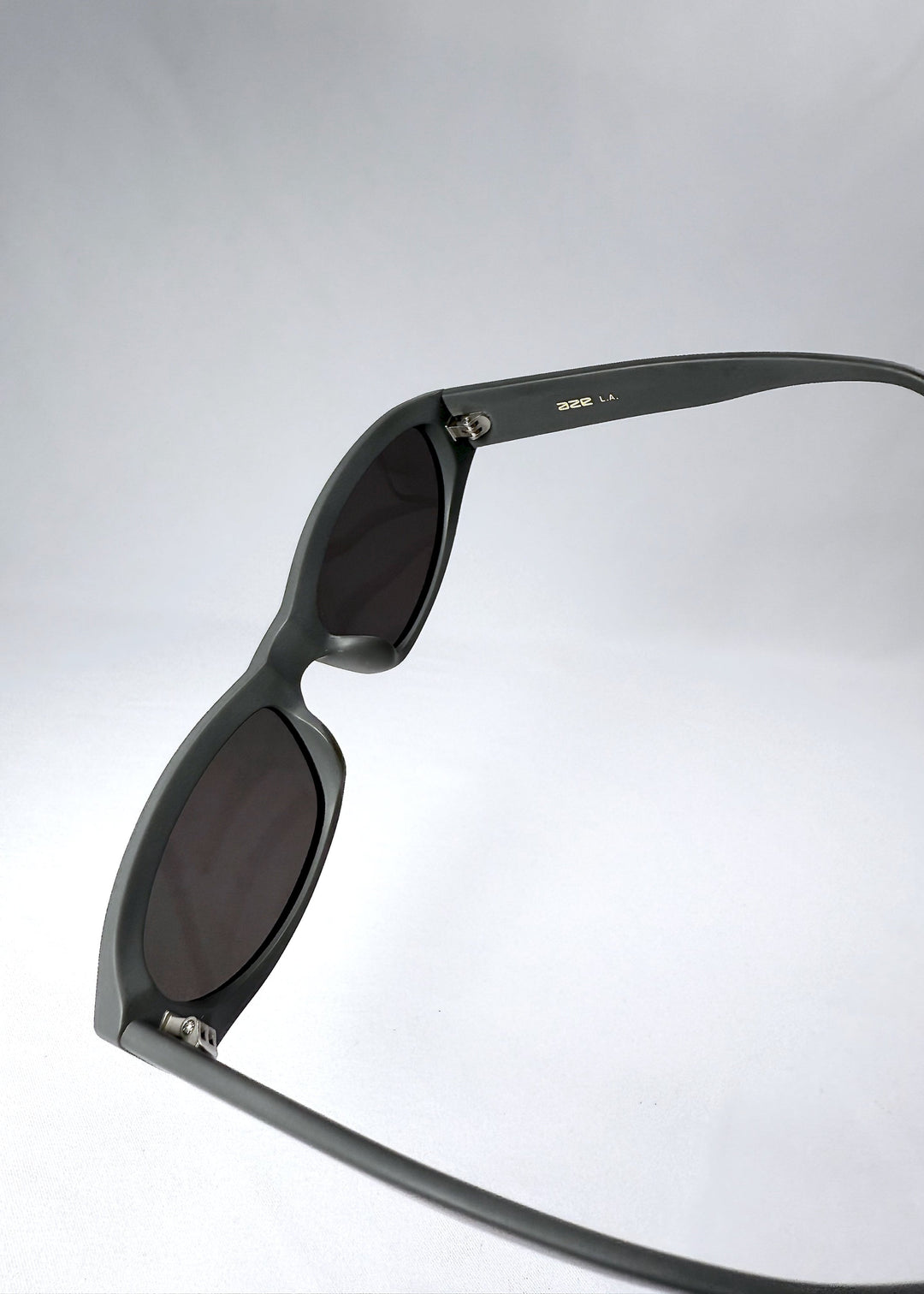 Lens and frame close-up of Nebula Shade in Carbon Ash, showing the deep grey polarized lens and thick cat-eye contour. 