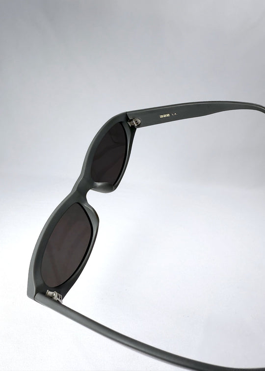 Lens and frame close-up of Nebula Shade in Carbon Ash, showing the deep grey polarized lens and thick cat-eye contour. 