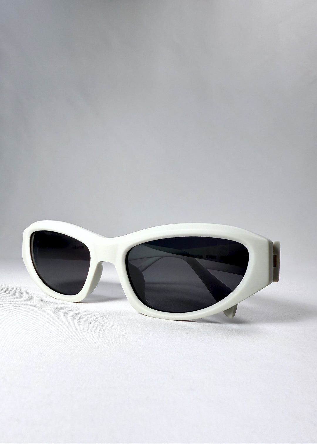 Close-up of the thick acetate frame of Nebula Shade in Glacial Ash, showing the lens curvature and smooth fog-white surface. 