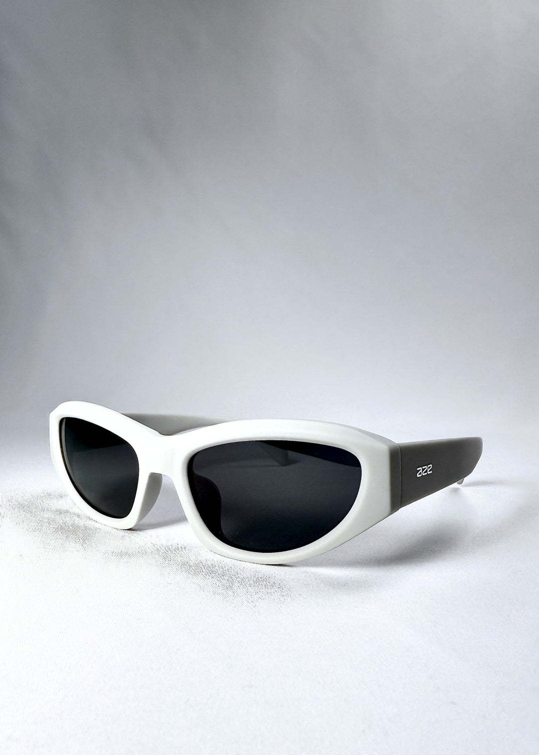 Angled front view of Nebula Shade sunglasses in Glacial Ash, highlighting the sculpted acetate build and cat-eye silhouette. 