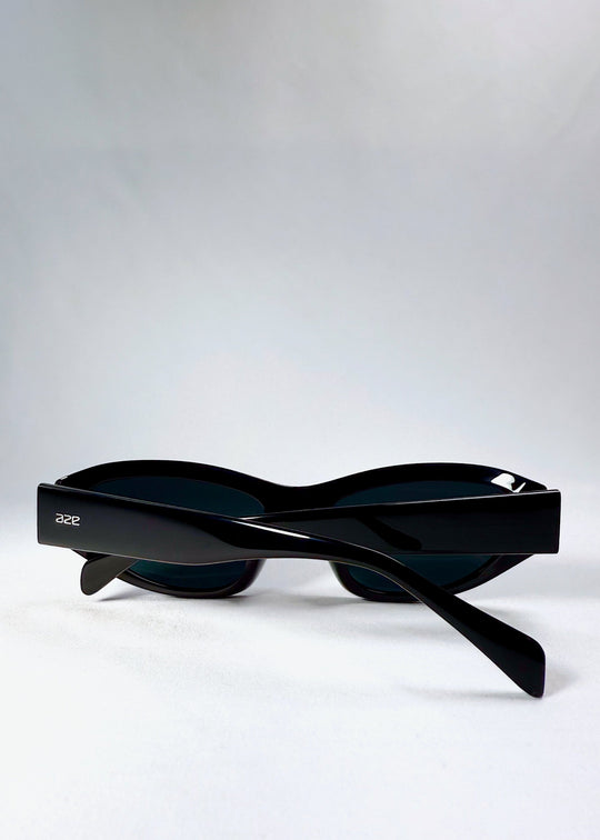 Folded view of Nebula Shade sunglasses in Obsidian Black, showing the compact folded structure and logo detail on the temples. 