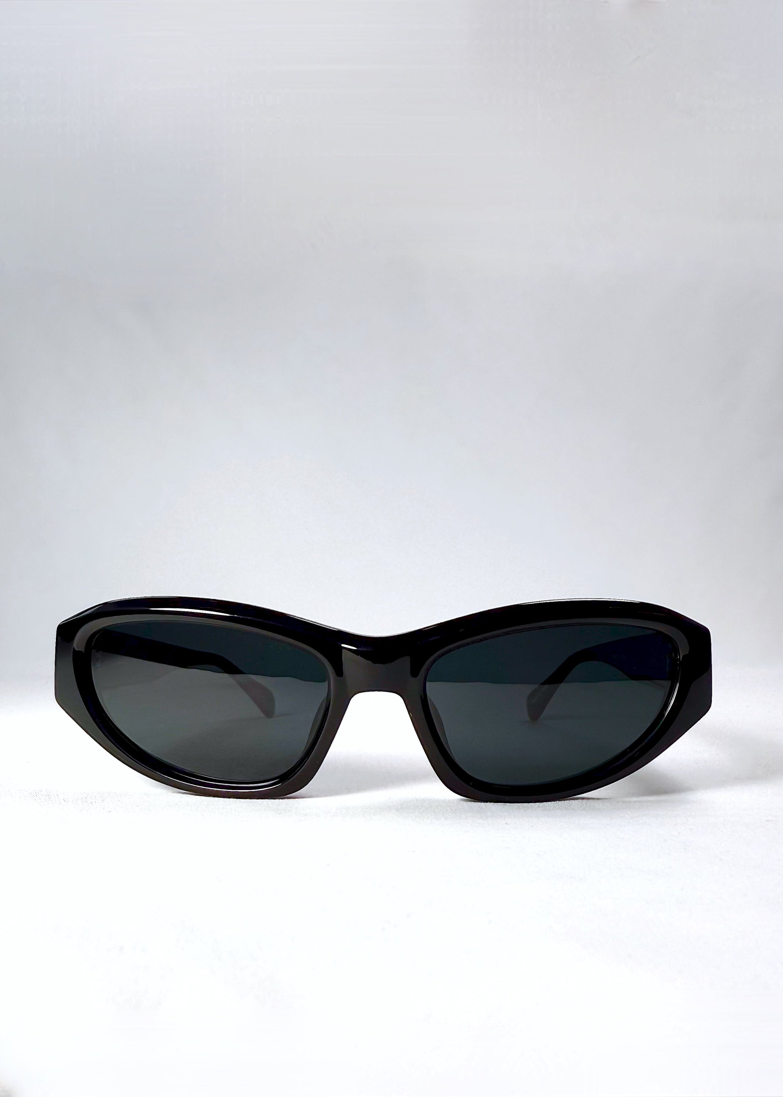 Front view of Nebula Shade sunglasses in Obsidian Black with smoky grey-green polarized lenses and glossy acetate cat-eye frame.