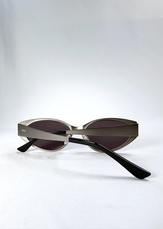 Close-up of the temple and engraved AZE logo on Nyx sunglasses in Ash Steel. 