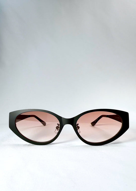 Front view of Nyx sunglasses in Blush Eclipse, showing the dark cat-eye frame and soft pink gradient lenses. 