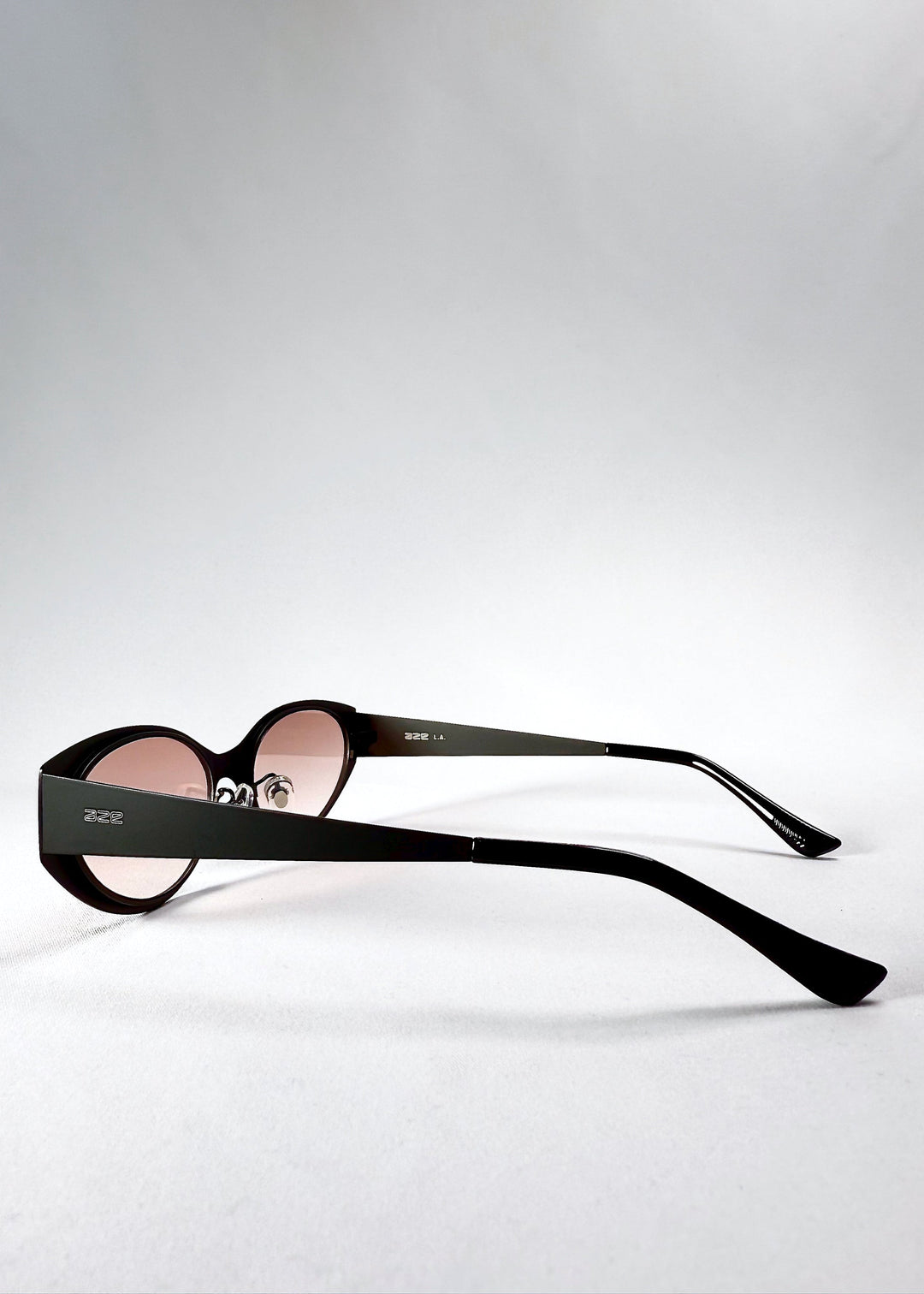 Side view of Nyx sunglasses in Blush Eclipse, showing the extended temples and pink gradient lenses. 