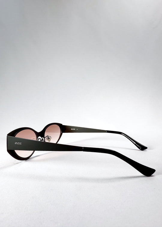 Side view of Nyx sunglasses in Blush Eclipse, showing the extended temples and pink gradient lenses. 
