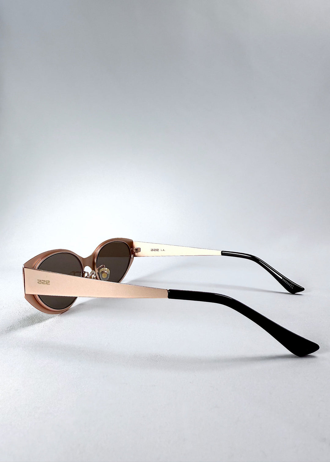 Close-up of the temple, AZE logo and satin bronze finish on Nyx sunglasses in Mocha Dusk. 
