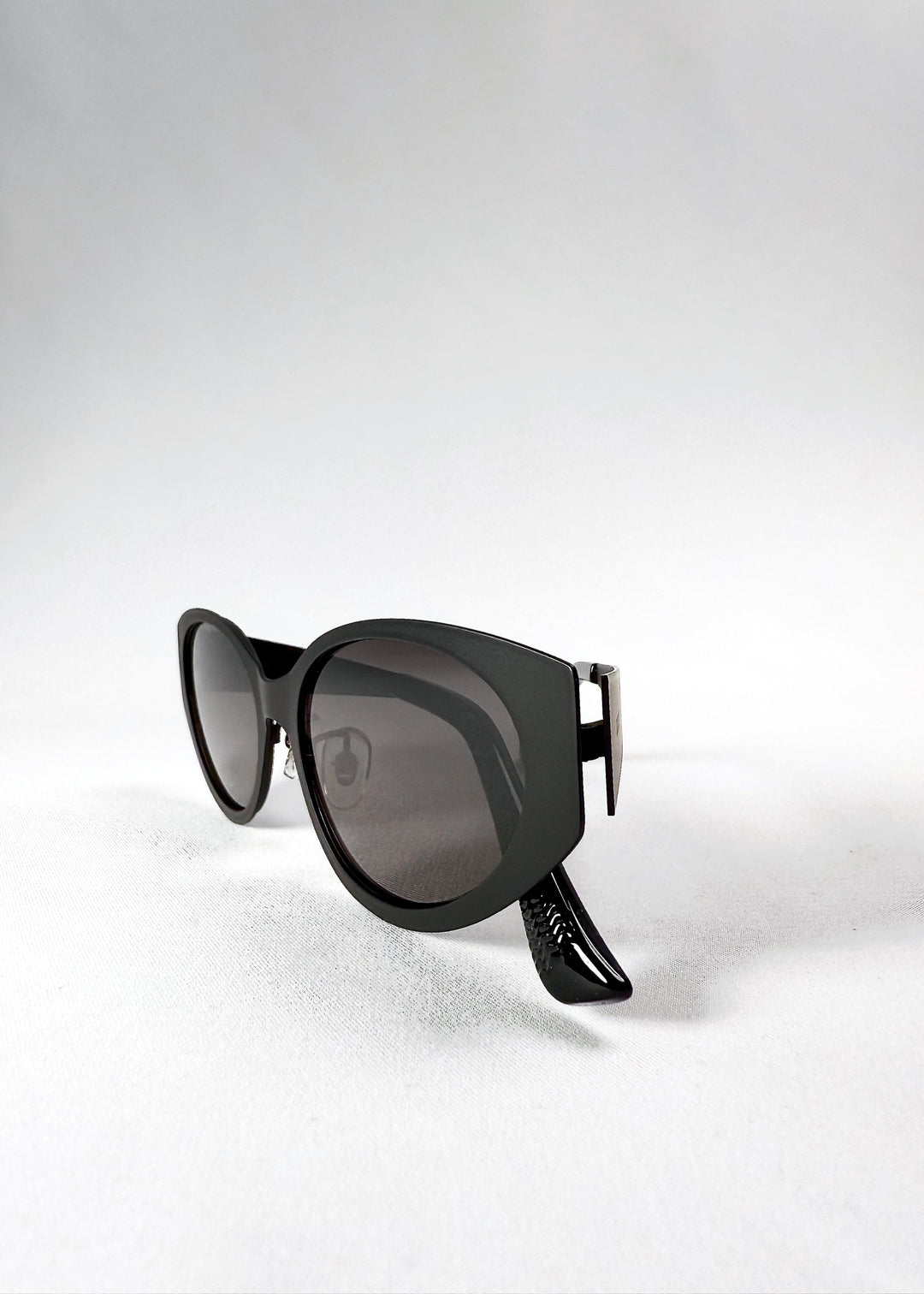 Folded view of Nyx sunglasses in Shadow Black, showing the compact frame and aligned hinges. 