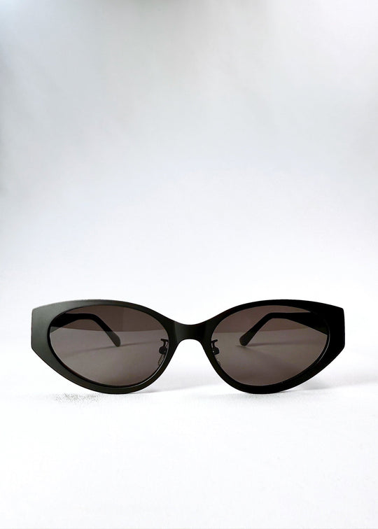 Front view of Nyx sunglasses in Shadow Black, showing the sculptural cat-eye frame and dark nylon lenses. 