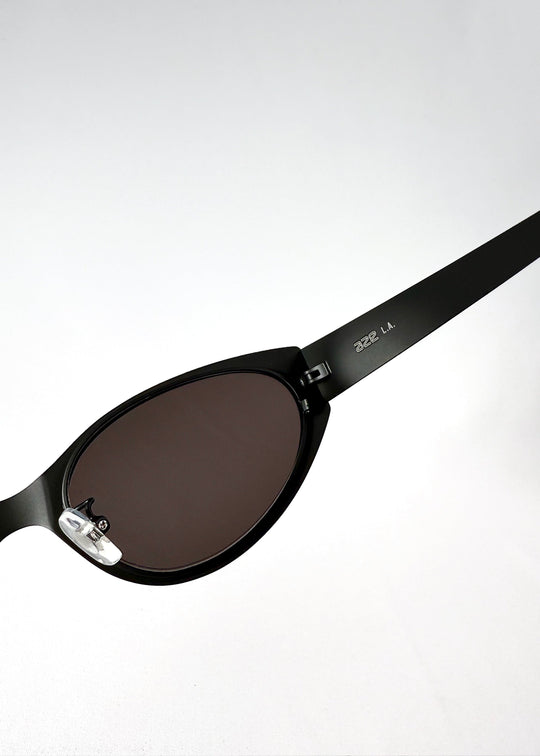 Close-up of the lens and adjustable nose pad on Nyx sunglasses in Shadow Black. 