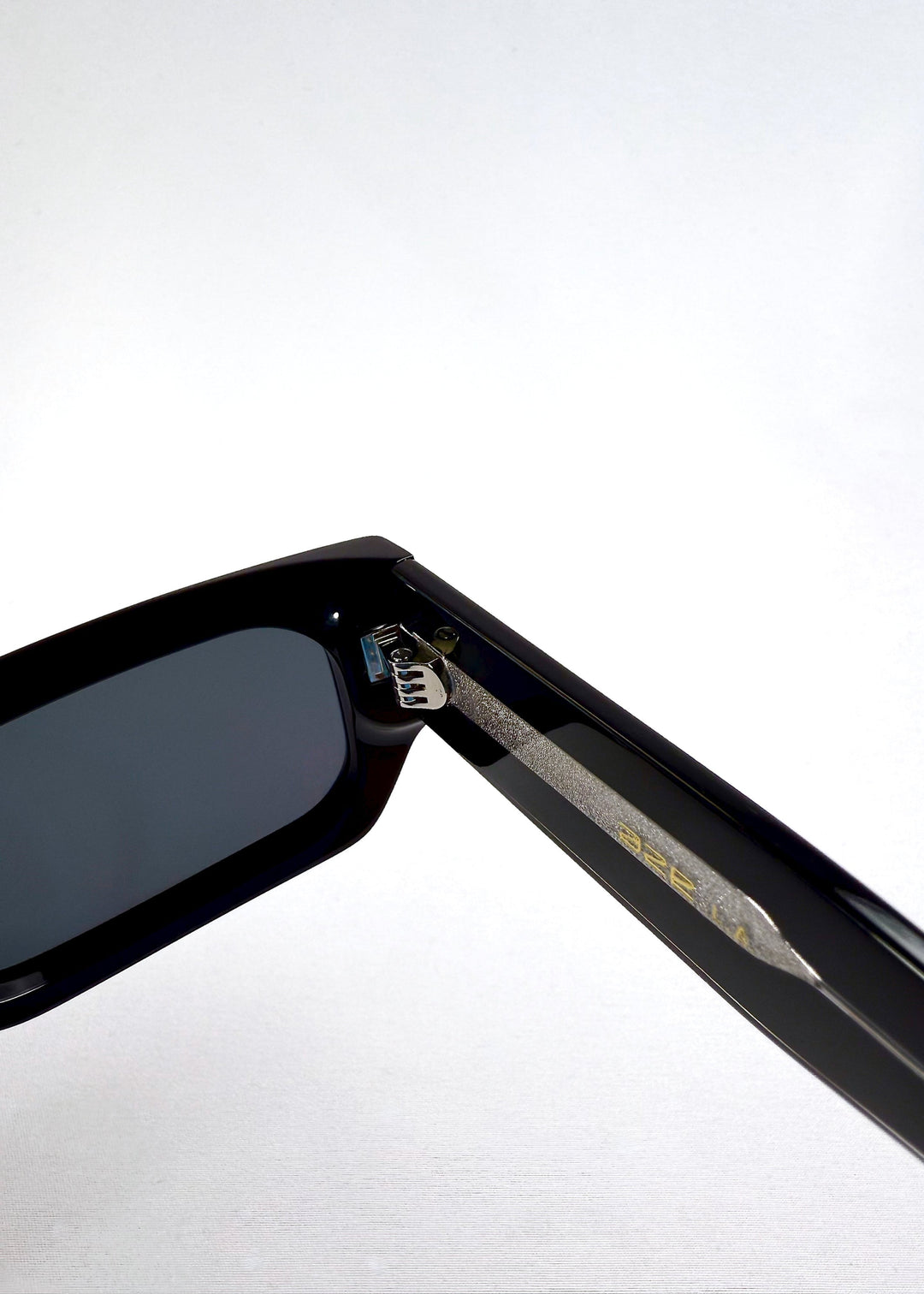 Macro closeup of the hinge and inner temple of Oblivion Trace sunglasses, emphasizing durable build and precision hardware. 