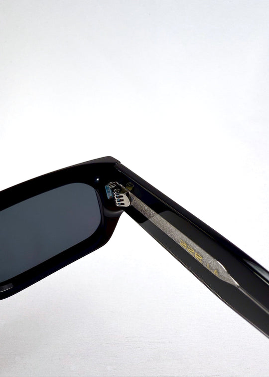 Macro closeup of the hinge and inner temple of Oblivion Trace sunglasses, emphasizing durable build and precision hardware. 