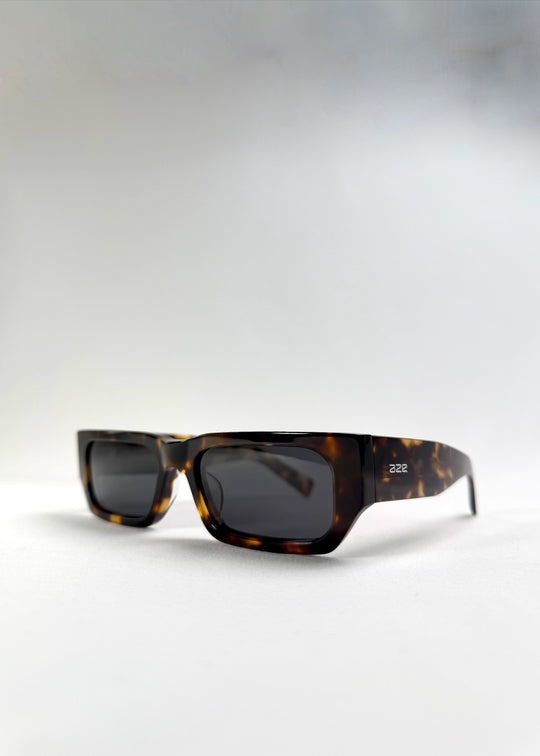 Angled front view of Oblivion Trace in Tortoise, highlighting the sharp silhouette and warm tortoiseshell tones. 