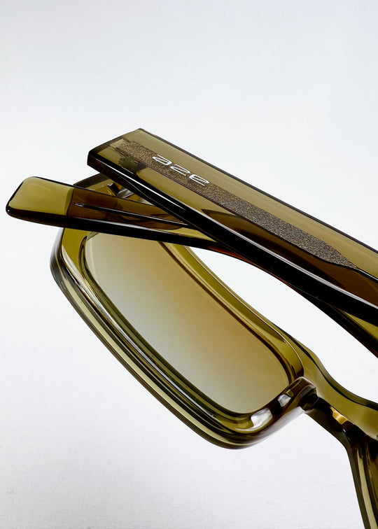 Detailed angle of the Oblivion Trace - Verdant Gold sunglasses showing the sculpted acetate frame and arm connection. 
