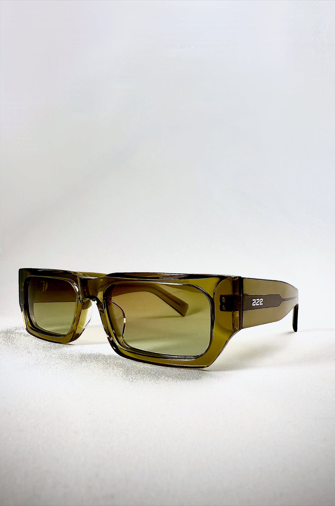 Oblivion Trace sunglasses in Verdant Gold, acetate frame viewed from front angle with translucent green tone. 
