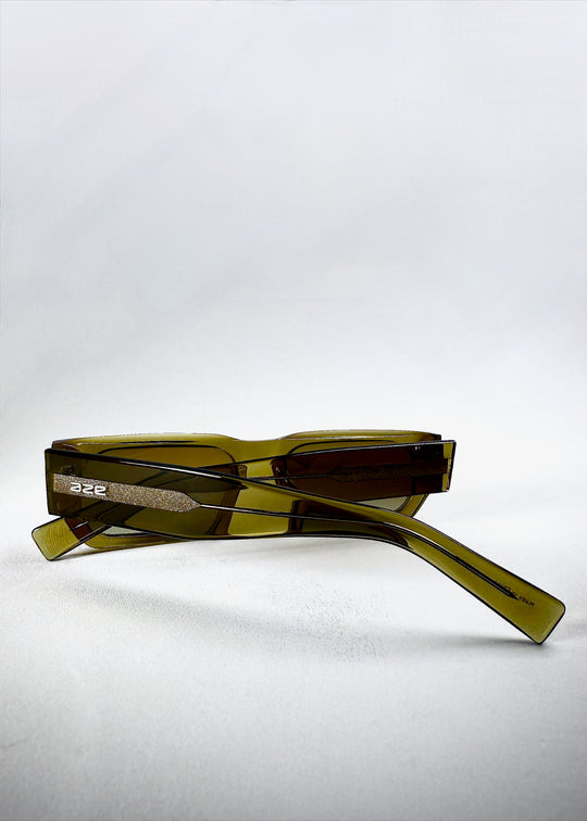 Close-up of temple on Oblivion Trace sunglasses in Verdant Gold, featuring embossed Aze logo and textured acetate. 