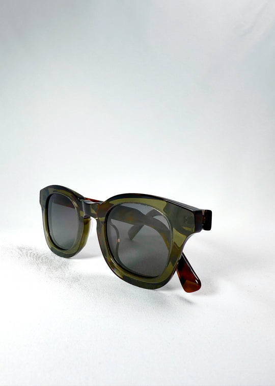 Folded three-quarter view of Phantom Verge in Ash Tortoise, showing the olive-green acetate front and tortoiseshell temple arms. 