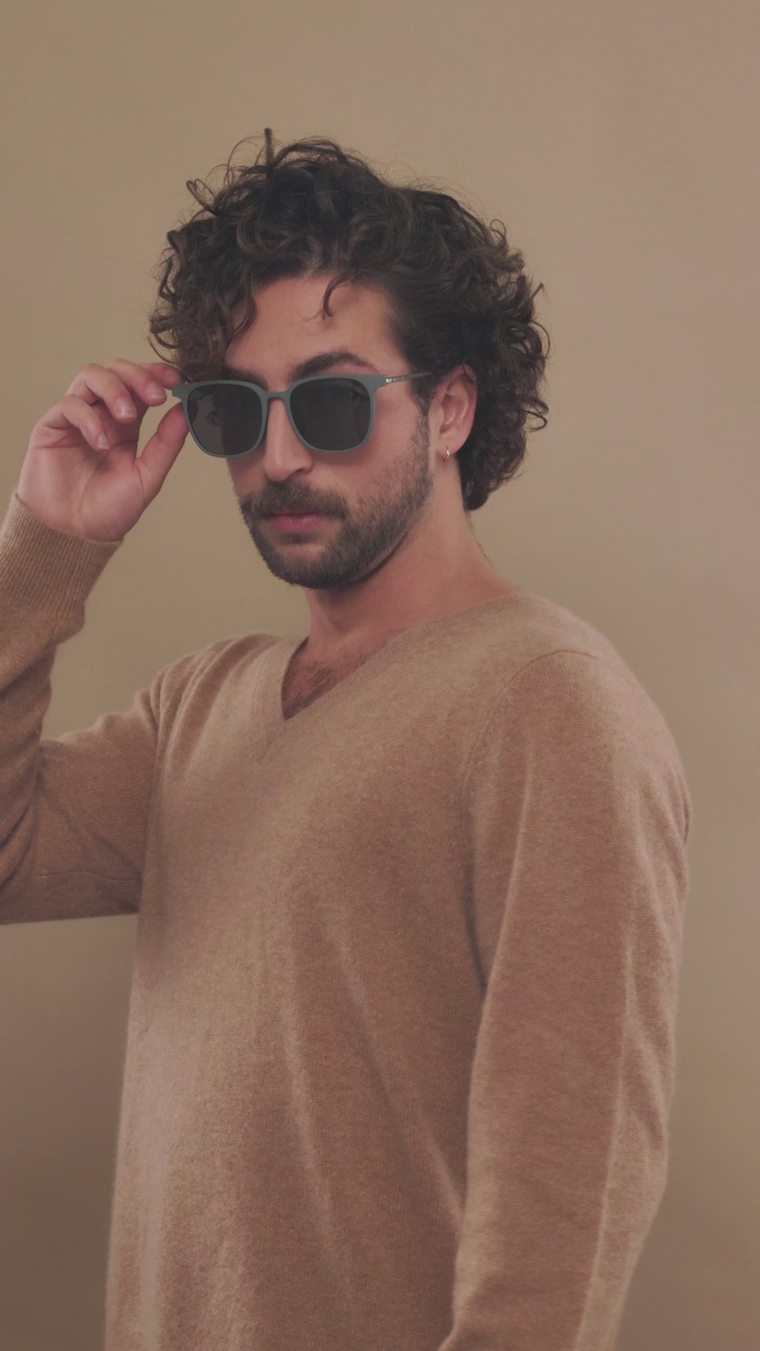 Lifestyle video of a male model wearing Achernar deep matte green sunglasses, highlighting their sophisticated yet versatile appeal. 