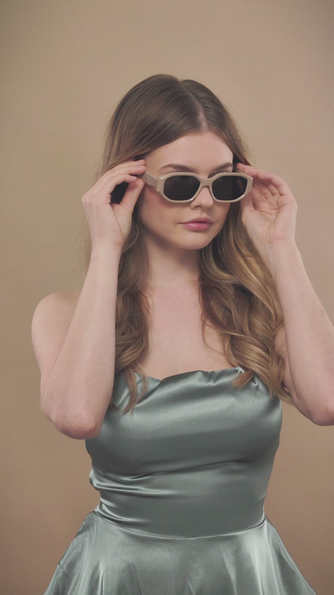 Lifestyle video of a female model wearing Lyra sunglasses in Creamy Beige. 