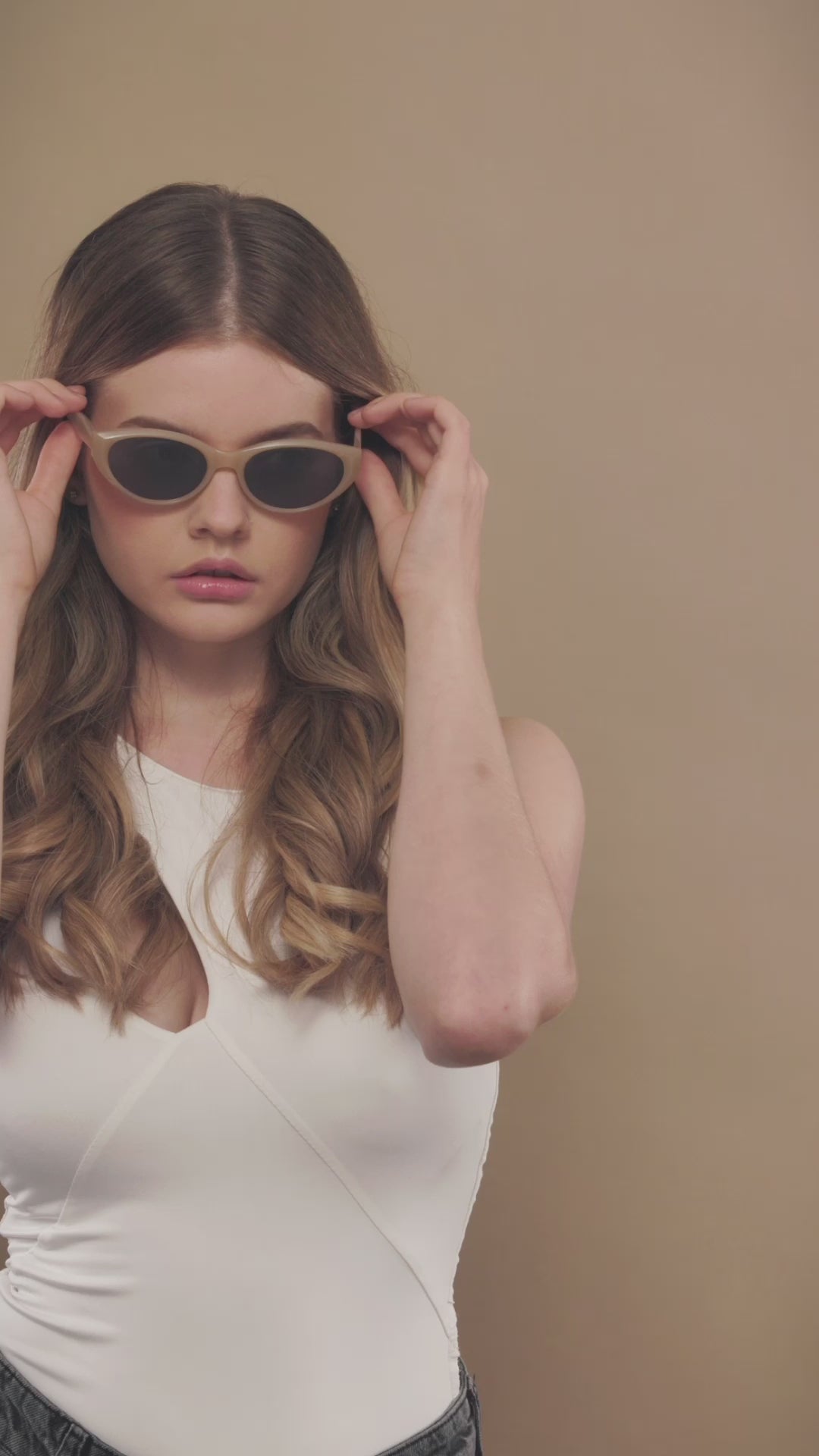 Lifestyle video of a female model wearing Chara sunglasses in Milky White. 