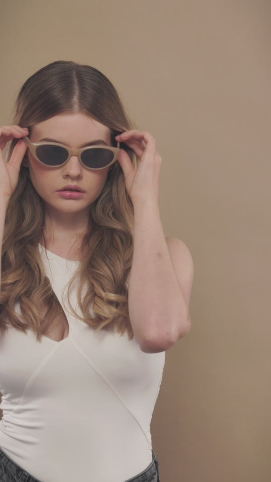 Lifestyle video of a female model wearing Chara sunglasses in Milky White. 