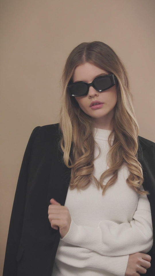 Lifestyle video of a female model wearing Bellatrix black sunglasses, showcasing its powerful and sophisticated style. 