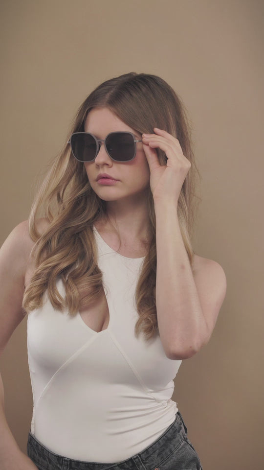 Lifestyle video of a female model wearing Spica sunglasses in Milk Tea Brown. 