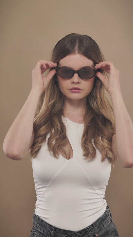 Lifestyle video of a female model wearing Chara sunglasses in Champagne Brown. 