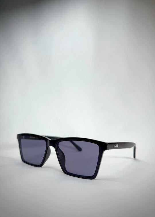Angled view of Rho Black TR90-Acetate prescription sunglasses with blue-grey lenses – a bold and sophisticated eyewear choice. 