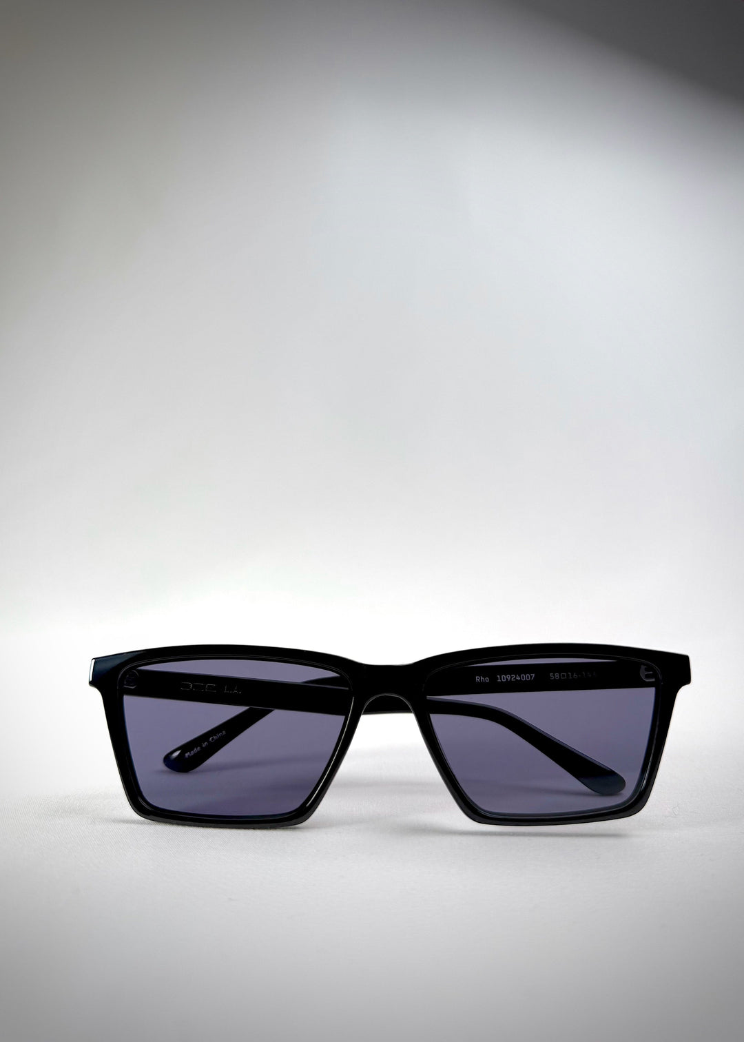 Folded front view of Rho Black TR90-Acetate prescription sunglasses with blue-grey lenses – showcasing a sleek and structured rectangular frame. 