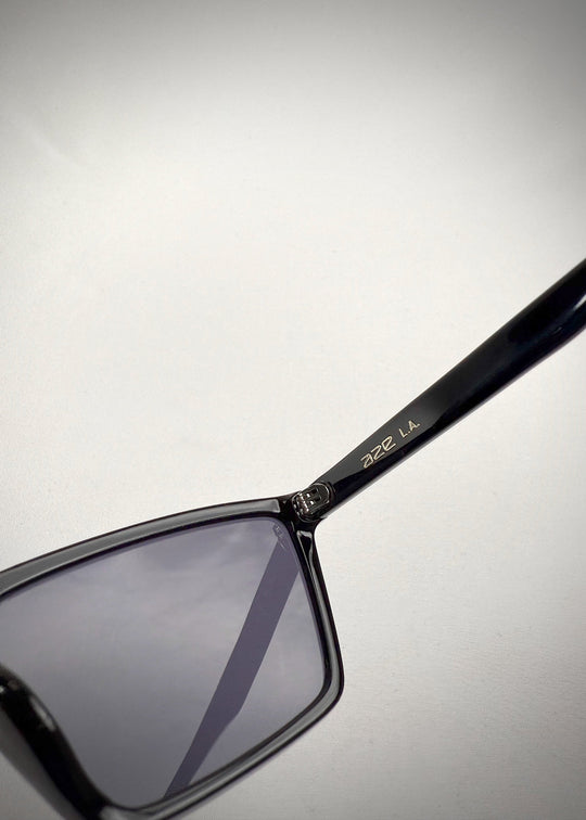 Close-up of Rho Black prescription sunglasses, showing the hinge detail and the engraved “Aze LA” branding on the acetate temple. 