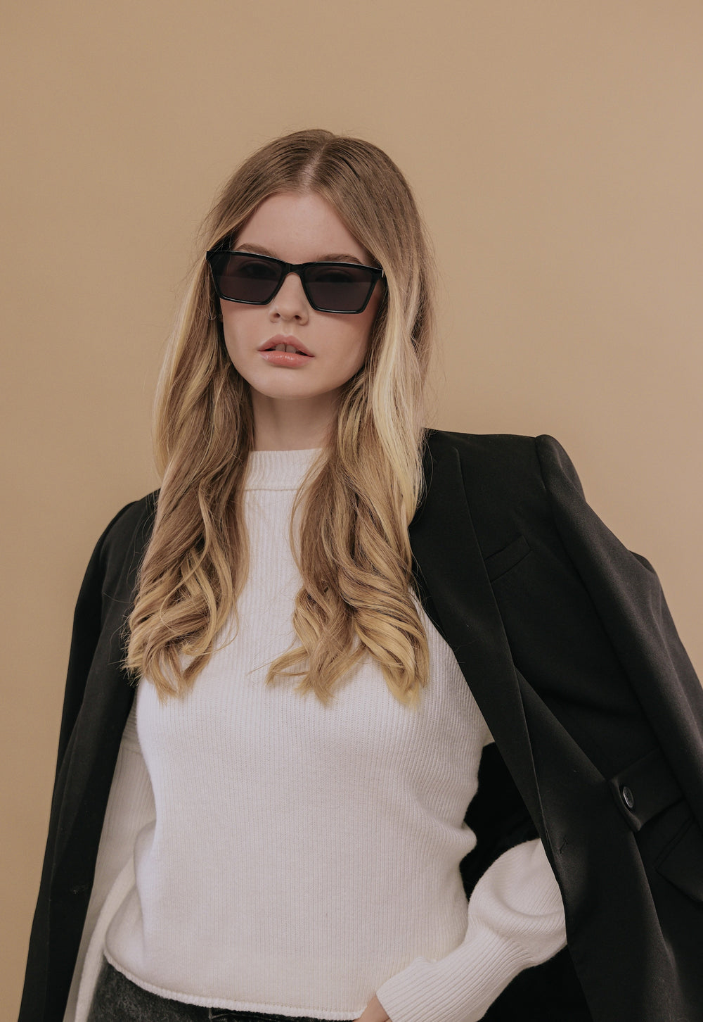 Female model wearing Rho Black sunglasses, demonstrating the contemporary and versatile style of the eyewear.