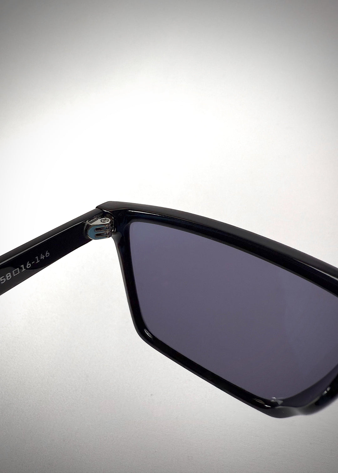 Close-up of the temple of Rho Black sunglasses, showcasing the glossy black finish and quality craftsmanship. 