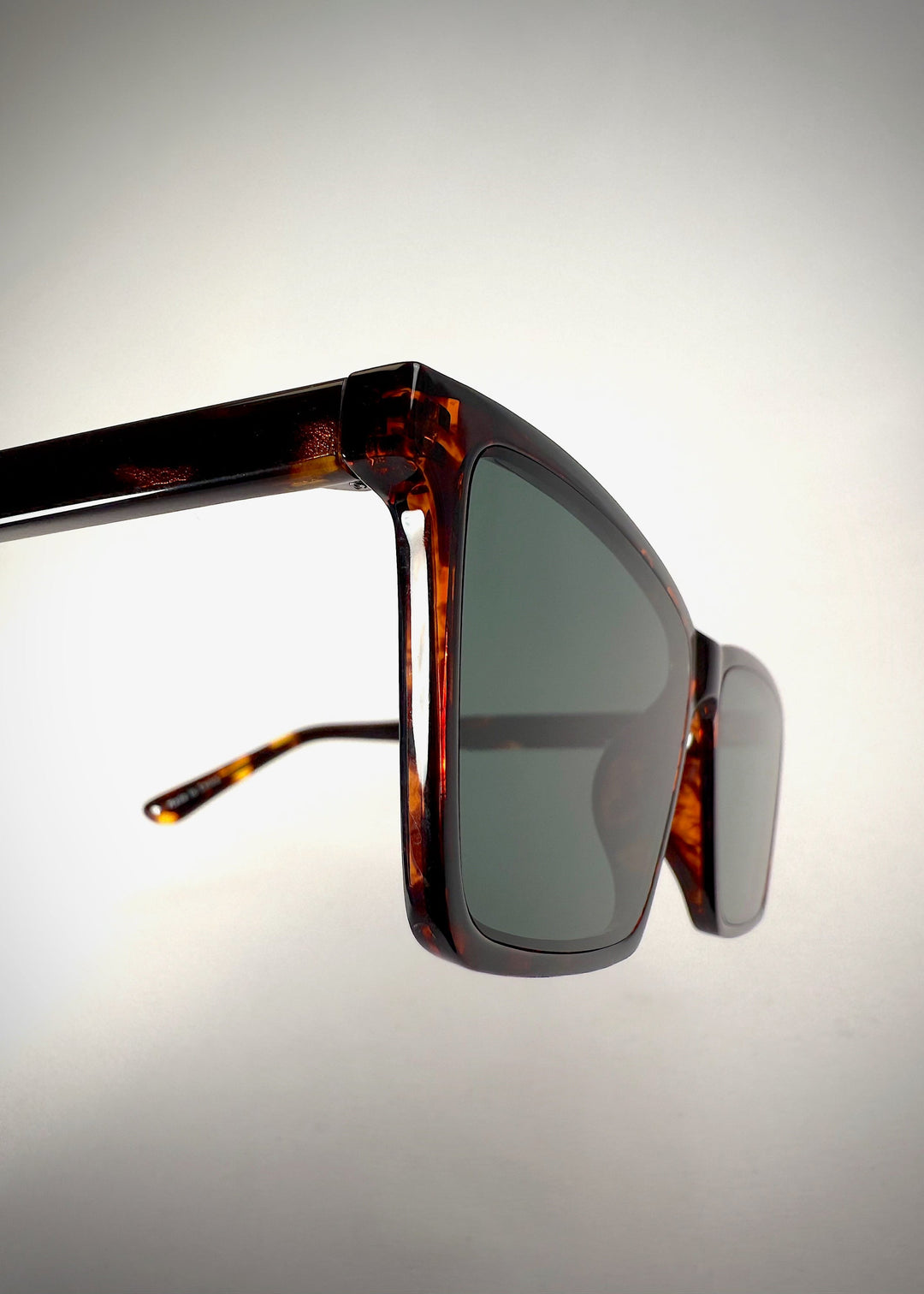 Close-up of Rho Tortoiseshell acetate prescription sunglasses, highlighting the rich tortoiseshell frame and hinge detail for a refined look. 