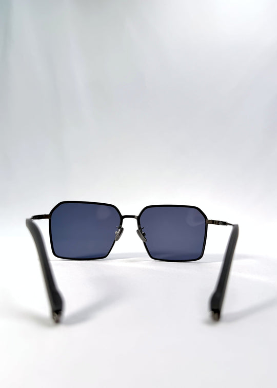 Back view of Rigel sunglasses in Blue Graphite, featuring an ultra-light frame with titanium temples, geometric lens shape, and polarized lenses, showing the inside frame and open temples. 