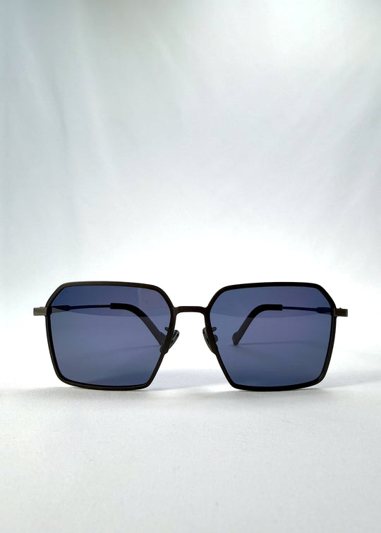 Front view of Rigel sunglasses in Blue Graphite, featuring an ultra-light frame with titanium temples, geometric lens shape, and polarized lenses, showing the full front silhouette. 