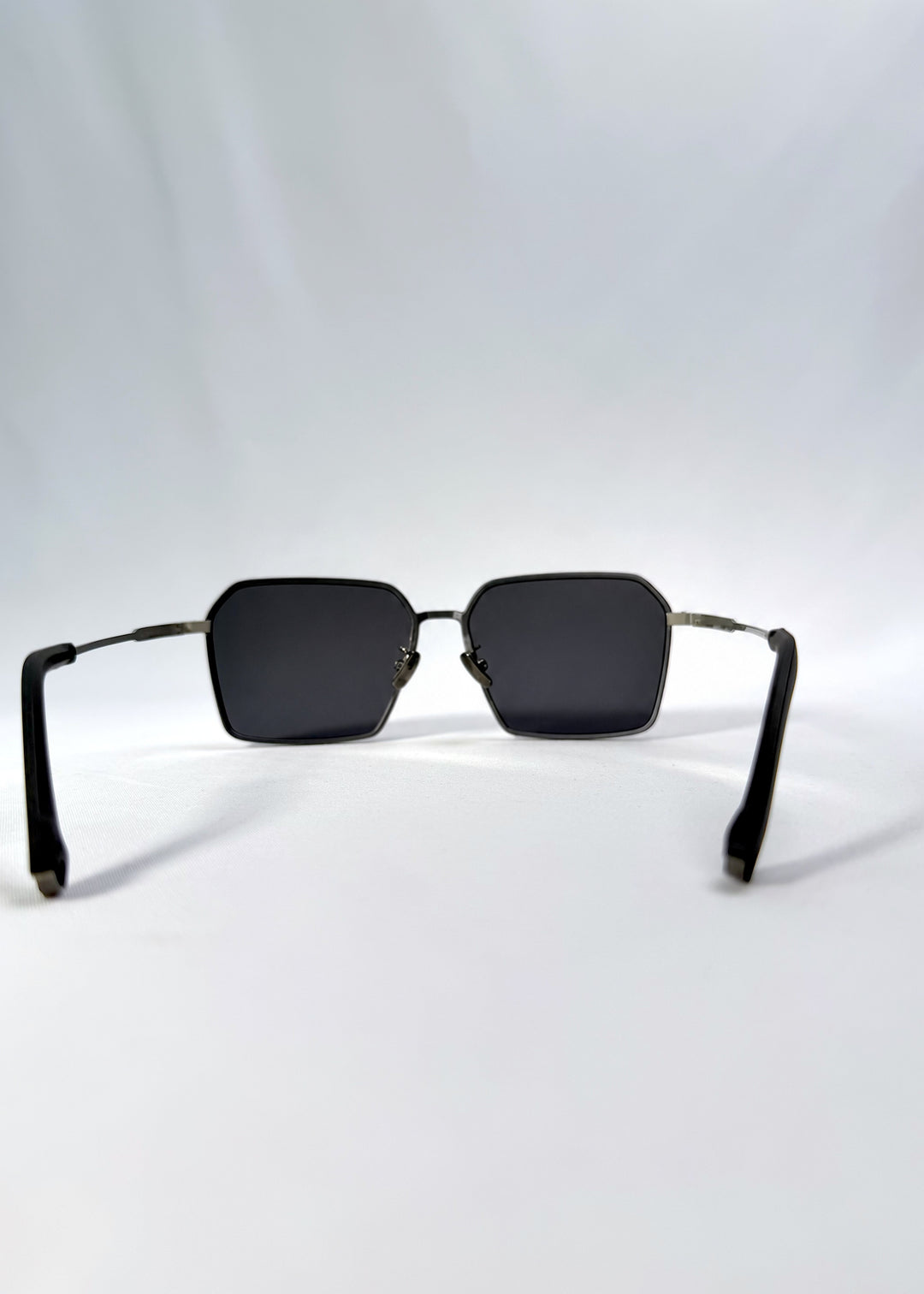 Back view of Rigel sunglasses in Matte Blue, featuring ultra-light titanium frame, geometric lens shape, and polarized lenses, showing the inside frame and open temples.