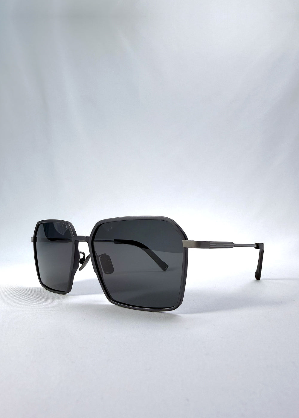 Three-quarter front view of Rigel sunglasses in Matte Blue, featuring ultra-light titanium frame, geometric lens shape, and polarized lenses, showing the front shape and temple profile.