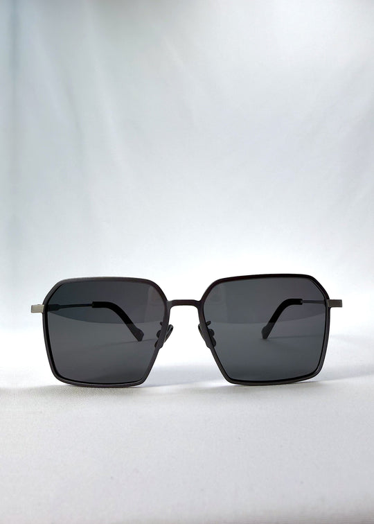 Front view of Rigel sunglasses in Gunmetal Ash, featuring an ultra-light frame with titanium temples, geometric lens shape, and polarized lenses, showing the full front silhouette. 