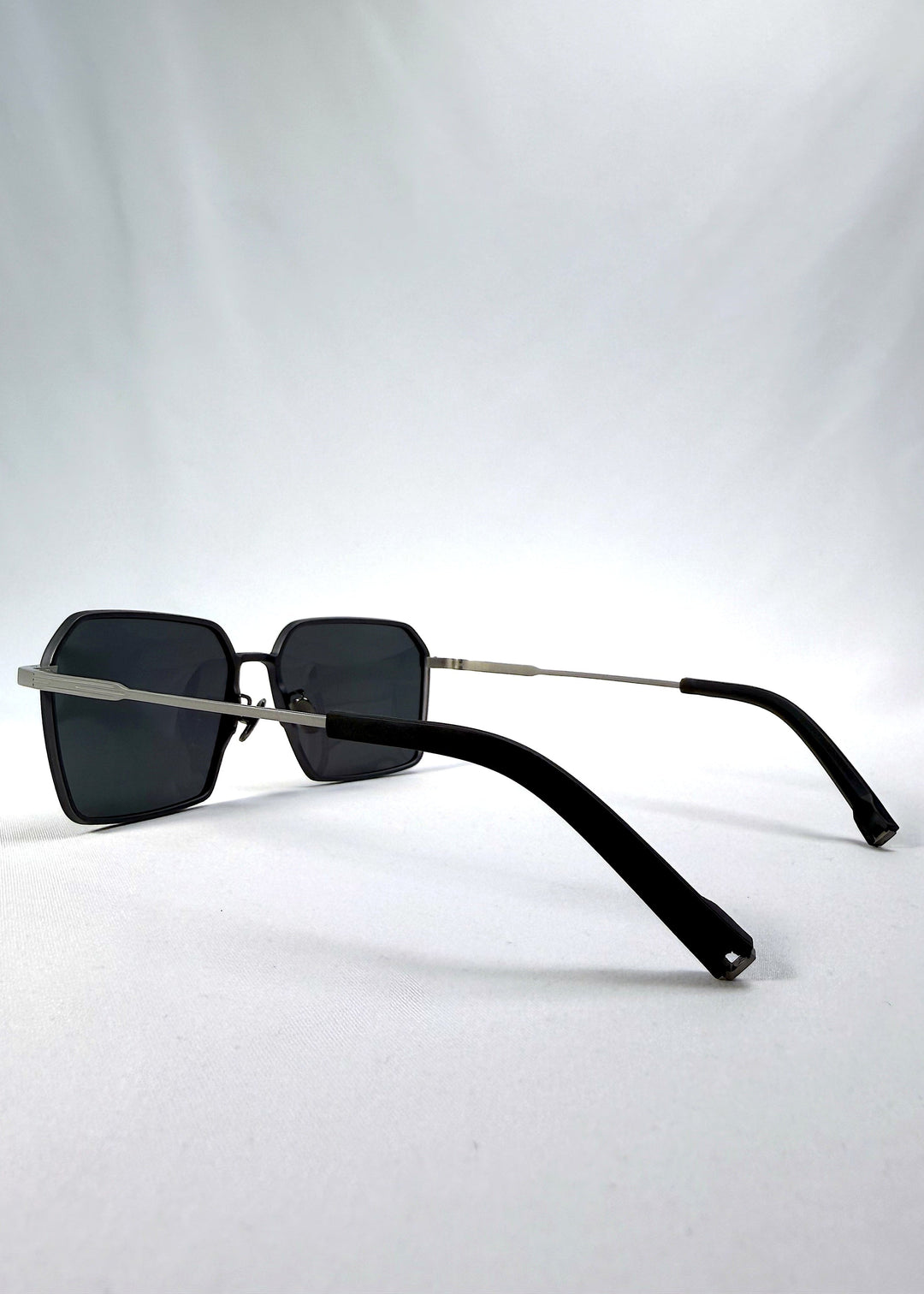 Side-angle view of Rigel sunglasses in Gunmetal Ash, featuring an ultra-light frame with titanium temples, geometric lens shape, and polarized lenses, showing the lens shape and temple profile. 