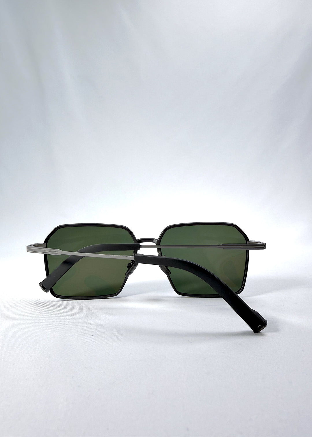 Folded view of Rigel sunglasses in Matte Gray, featuring ultra-light titanium frame, geometric lens shape, and polarized lenses, showing the folded temples and frame profile.