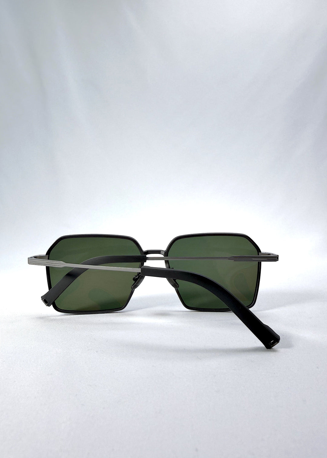 Folded view of Rigel sunglasses in Olive Smoke, featuring an ultra-light frame with titanium temples, geometric lens shape, and polarized lenses, showing the folded temples and frame profile. 