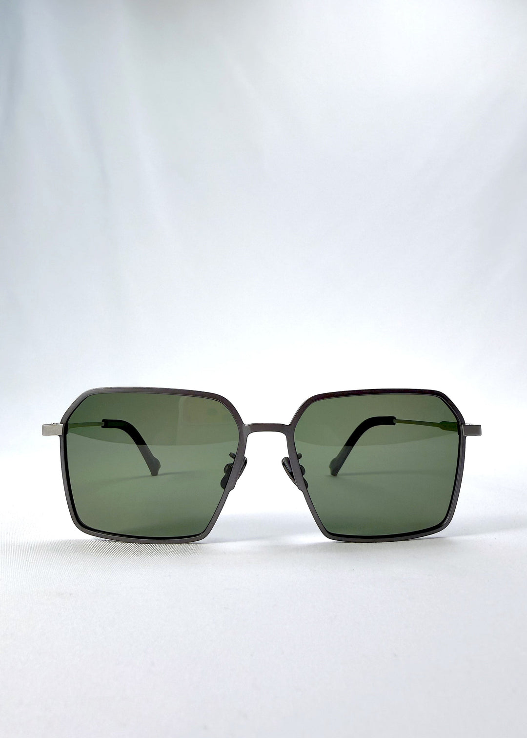 Front view of Rigel sunglasses in Olive Smoke, featuring an ultra-light frame with titanium temples, geometric lens shape, and polarized lenses, showing the full front silhouette. 