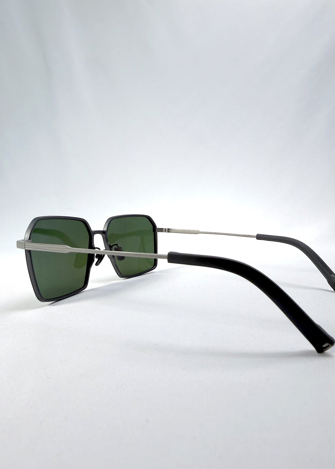 Side-angle view of Rigel sunglasses in Olive Smoke, featuring an ultra-light frame with titanium temples, geometric lens shape, and polarized lenses, showing the lens shape and temple profile. 