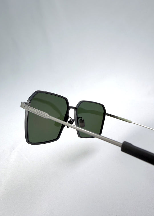 Close-up temple detail view of Rigel sunglasses in Matte Gray, featuring ultra-light titanium frame, geometric lens shape, and polarized lenses, showing the temple arm and hinge area.