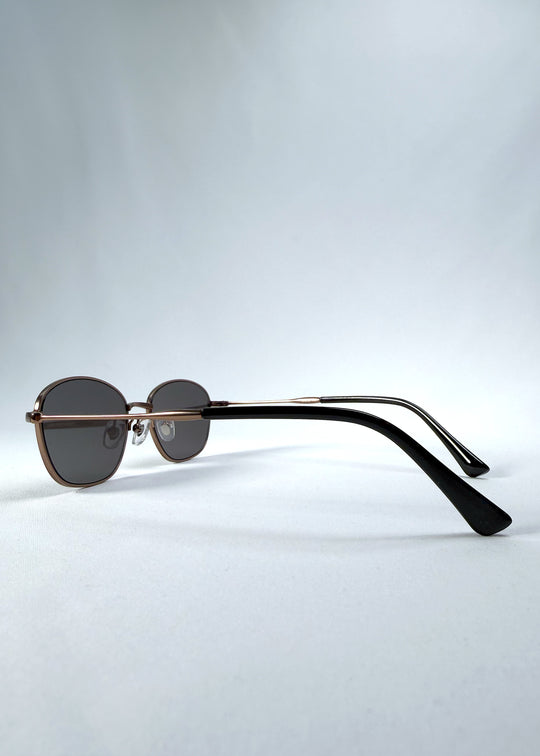 Back-angle view of AZE Selene Line sunglasses in Mocha Alloy, featuring a slim bronze-tone oval metal frame and smoky brown lenses, showing the rear frame structure and temple alignment.