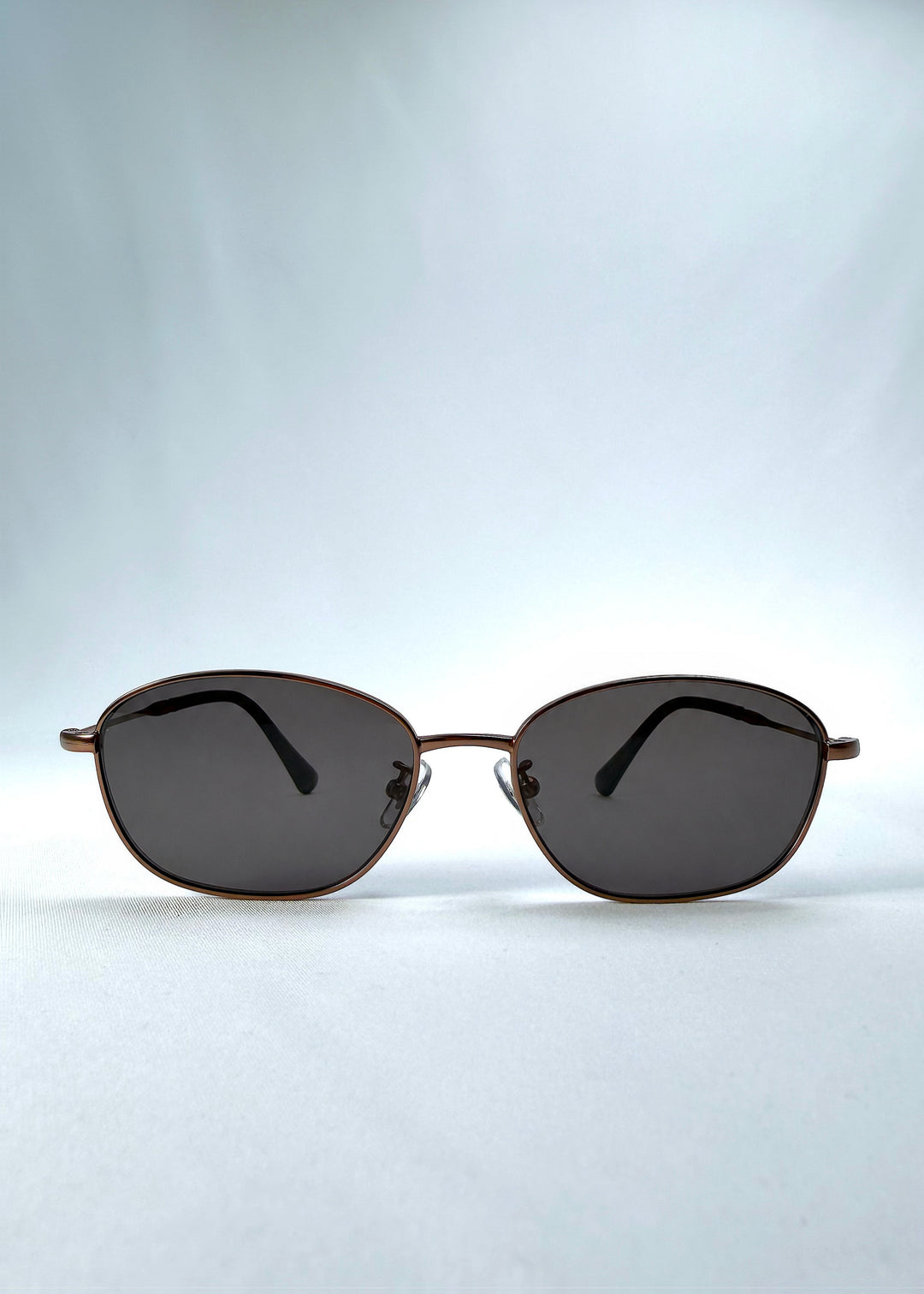 Front view of AZE Selene Line sunglasses in Mocha Alloy, featuring a slim bronze-tone oval metal frame and smoky brown lenses, showing the full front silhouette.